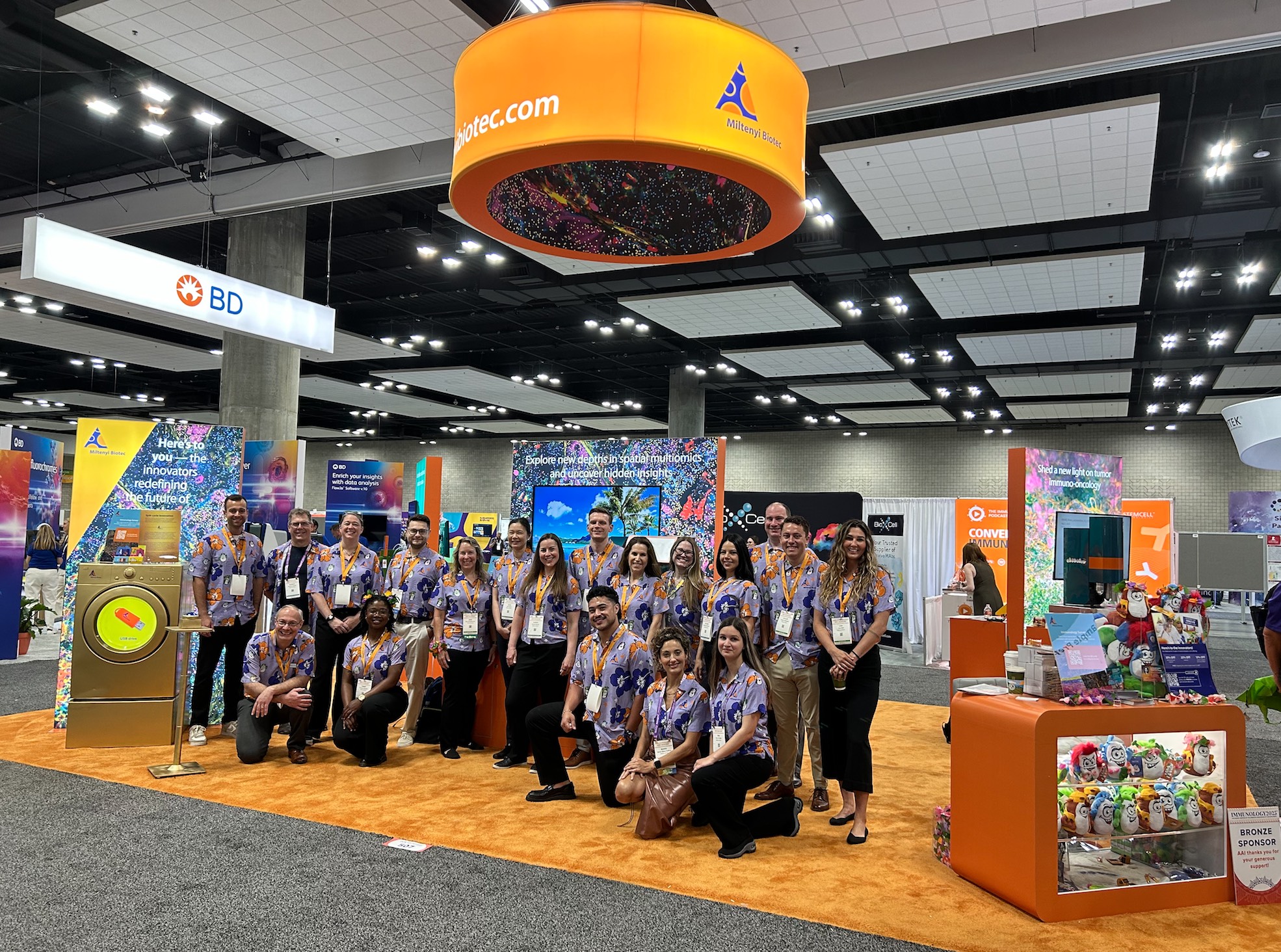 Exhibit staff in matching event shirts posing at the booth