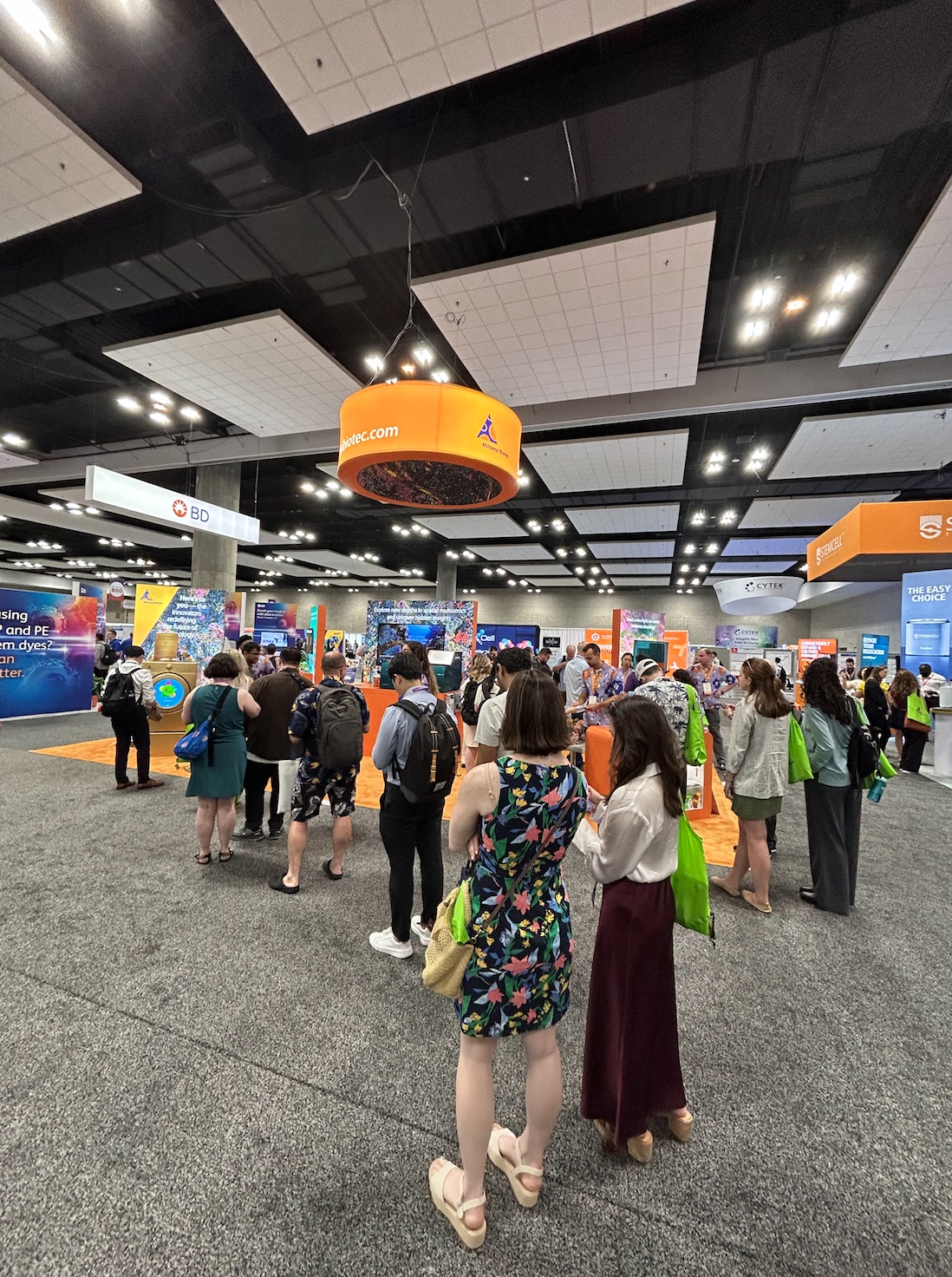 Attendees gathered around the exhibit booth
